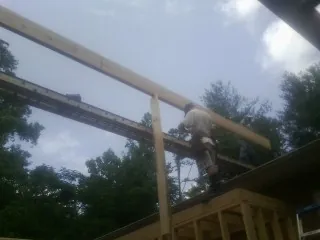 Carpenter setting a ridge beam over a new addition frame — Ice Dam Removal by Roofing Brothers in Allston
