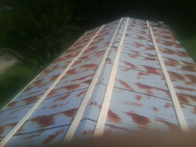 Rusted metal roof panels with new wood purlins before replacement — Storm Damage Roof Repair in Allston by Roofing Brothers