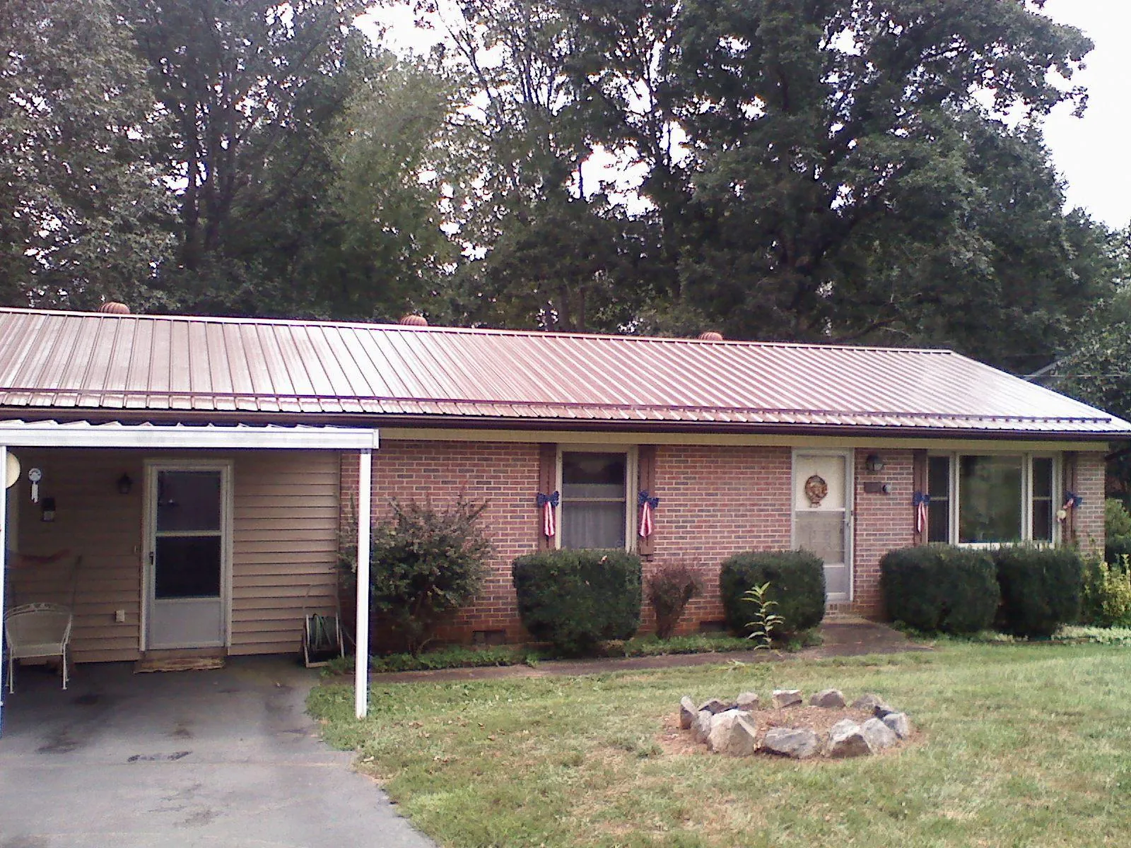 Bronze metal roof and carport on a brick ranch home — Roof Repair work by our crew in Allston